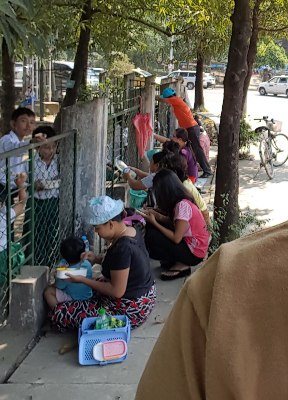 Apparently at lunch parents come to schools to literally feed their children through the fence. Not sure if it's all children and all schools, but it's certainly happening here. Also happening here is me pretending to take a selfie while actually focussing on the background. Pretty sure the kid on the left busted me.